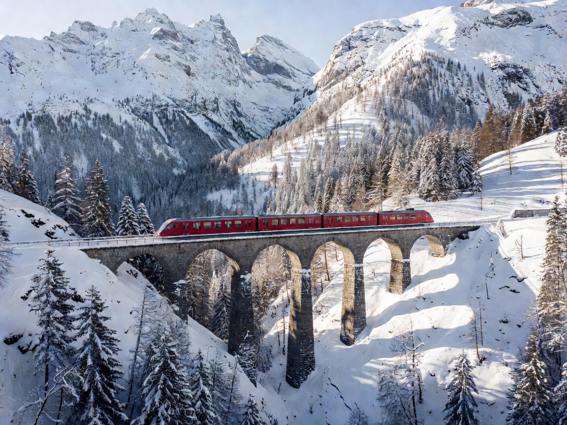Swiss red panoramic train traveling over Landwasser viaduct in winter mountains
